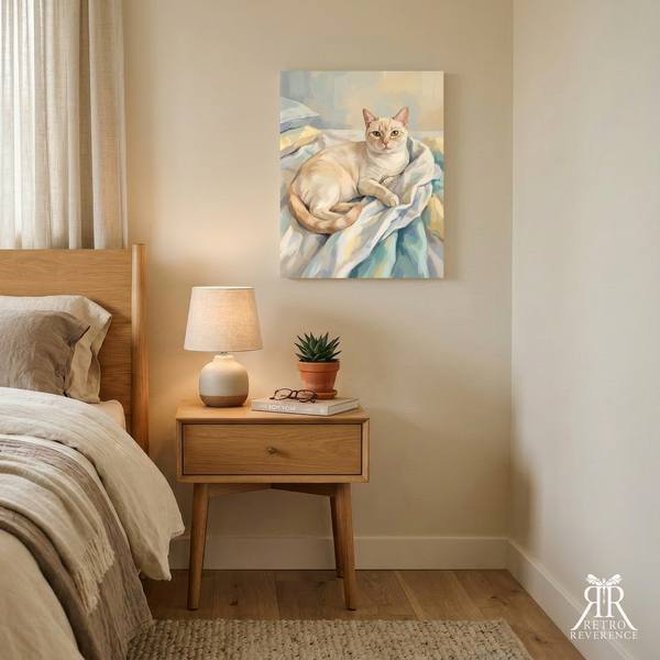 Custom cat portrait of a cat settled on a rumpled duvet, making the bed impossible, framed and hanging on a wall at home